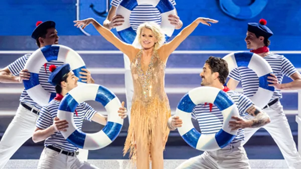 Sophie Davant en robe dorée à franges et paillettes sur la scène de Danse avec les stars 2025, entourée de danseurs en marinière tenant des bouées, chorégraphie sur « Mama Mia » d'Abba.