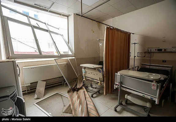 Ispahan, 12 mars 2026 : vue de l'intérieur de l'hôpital Khorshid avec une chambre endommagée, plafond effondré, rideau tombé et équipements médicaux en désordre après une série d'explosions.