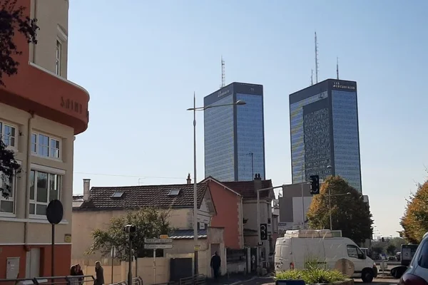 Les deux tours jumelles des Mercuriales à Bagnolet visibles au-dessus de bâtiments résidentiels bas sous un ciel bleu dégagé