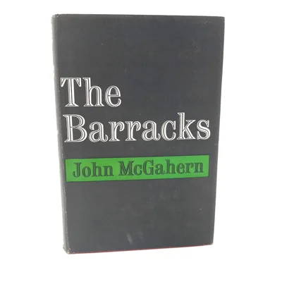 Couverture grise de l'édition originale de The Barracks de John McGahern, avec le titre en lettres blanches et le nom de l'auteur dans un bandeau vert.
